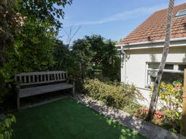 A garden with a wooden bench and plants at Harbour High Annex Fishguard