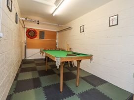 A game room with a pool table foosball table and dartboard on tiled floor at 2 Mountain View in Chirk