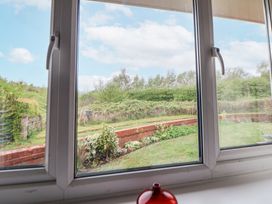 A view of a garden with grass and plants outside a window at 2 Mountain View in Chirk