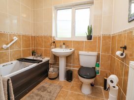 A bathroom with a bathtub sink toilet and window at 2 Mountain View in Chirk