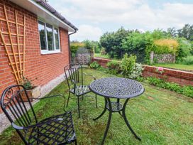 A garden with a table and chairs at 2 Mountain View in Chirk