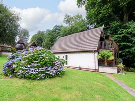 A house with a balcony and garden at Driftwood - 54 Valley Lodge, St Ann's Chapel, Cornwall