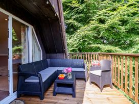 A balcony with seating and a table at Driftwood - 54 Valley Lodge, St Ann's Chapel, Cornwall
