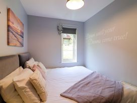 A bedroom with a bed and window at Driftwood - 54 Valley Lodge, St Ann's Chapel, Cornwall