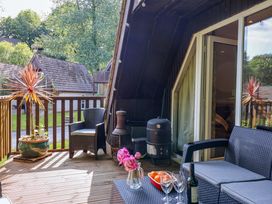 An outdoor deck with furniture and a barbecue grill at Driftwood - 54 Valley Lodge, St Ann's Chapel, Cornwall
