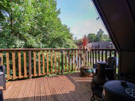 An outdoor deck with chairs and a potted plant at Driftwood - 54 Valley Lodge St Ann's Chapel, Cornwall