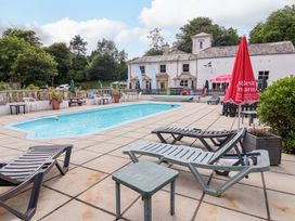 An outdoor swimming area with loungers and tables at Driftwood - 54 Valley Lodge St Ann's Chapel, Cornwall