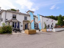 A pub exterior with seating and flags at Driftwood - 54 Valley Lodge, St Ann's Chapel, Cornwall