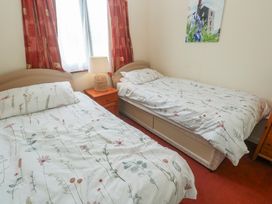 A bedroom with two beds and a lamp at 14 Bosvigo Ruan Major near Penhale