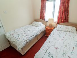 A bedroom with two single beds and a lamp at 14 Bosvigo in Ruan Major near Penhale