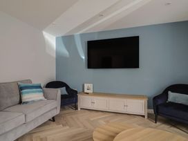 A living room with a television and seating at Wagtail Cottage Lyme Regis