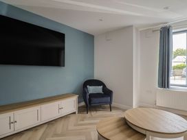 A living room with a tv and an armchair at Wagtail Cottage in Lyme Regis