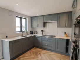 A kitchen with cabinets, sink and window at Wagtail Cottage in Lyme Regis