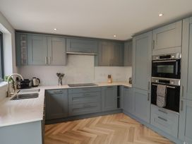 A kitchen with cabinets, sink, ovens, and utensils at Wagtail Cottage in Lyme Regis