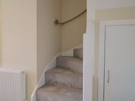 A staircase with carpet and a door at Wagtail Cottage in Lyme Regis