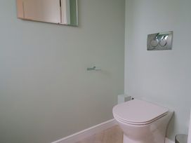 A bathroom with a toilet and a mirror at Wagtail Cottage in Lyme Regis