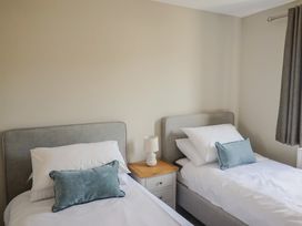 A bedroom with two single beds and a lamp at Wagtail Cottage in Lyme Regis