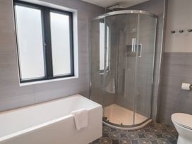 A bathroom with a bathtub and shower at Wagtail Cottage in Lyme Regis