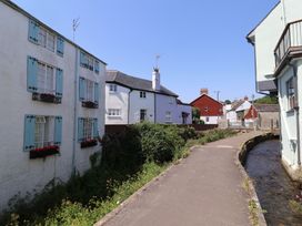 A view of houses along a pathway next to a stream at Wagtail Cottage in Lyme Regis