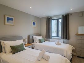 A bedroom with two beds and a window at Wagtail Cottage Lyme Regis