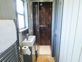 A small bathroom with a shower cubicle a sink a towel rail and a window at Dandelion in Ashby cum Fenby near Waltham