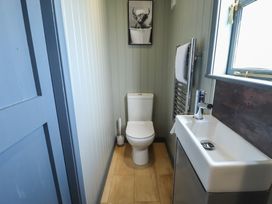 A small bathroom with a toilet a sink a towel radiator a window and a picture on the wall at Dandelion in Ashby cum Fenby near Waltham