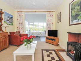 A living room with a sofa and a television at Jordan Cottage in Fowey