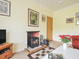 A living room with a fireplace and television at Jordan Cottage in Fowey
