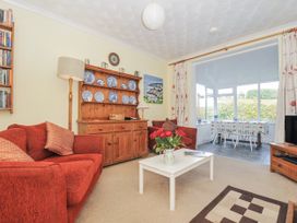 A living room with a sofa, sideboard and television at Jordan Cottage in Fowey