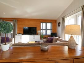A living room with sofas TV and lamp at Angel Lodge No 27 in Fornham St Genevieve near Bury St Edmunds