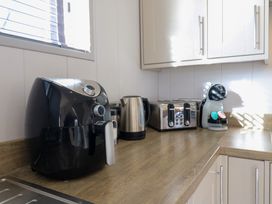 A kitchen countertop with an air fryer kettle toaster and coffee machine at Angel Lodge - No 27 in Fornham St Genevieve near Bury St Edmunds