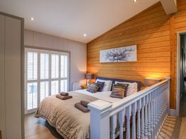 A bedroom with a double bed pillows bedside tables and lamps at Angel Lodge - No 27 in Fornham St Genevieve near Bury St Edmunds