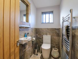 A bathroom with a toilet sink mirror towel rack and window at Angel Lodge - No 27 in Fornham St Genevieve near Bury St Edmunds