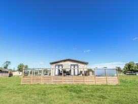 A cabin with a wooden deck and outdoor furniture at Angel Lodge - No 27, Fornham St Genevieve near Bury St Edmunds