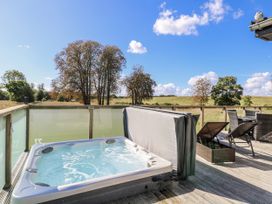An outdoor area with a hot tub and seating at Angel Lodge - No 27 near Bury St Edmunds