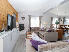 A living room with a sofa and television at Angel Lodge - No 27 Fornham St Genevieve near Bury St Edmunds