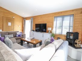 A living room with a sofa and television at Angel Lodge - No 27, Fornham St Genevieve near Bury St Edmunds