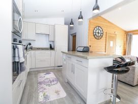 A kitchen with cabinets, stove, and a kitchen island at Angel Lodge - No 27 in Fornham St Genevieve near Bury St Edmunds