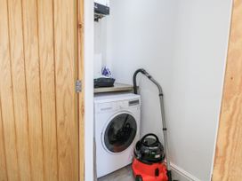 A laundry room with a washing machine and vacuum cleaner at Angel Lodge - No 27, Fornham St Genevieve near Bury St Edmunds