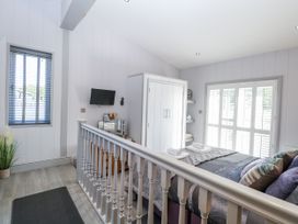 A bedroom with a bed and wardrobe at Angel Lodge - No 27 Fornham St Genevieve near Bury St Edmunds