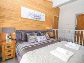 A bedroom with a bed and bedside table at Angel Lodge - No 27 near Fornham St Genevieve