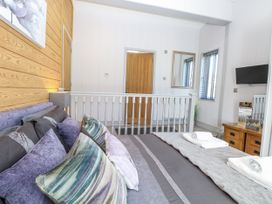 A bedroom with a bed and cushions at Angel Lodge - No 27 in Fornham St Genevieve near Bury St Edmunds