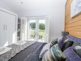 A bedroom with bed and wardrobe at Angel Lodge - No 27, Fornham St Genevieve near Bury St Edmunds