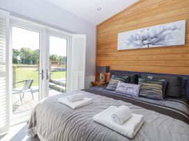 A bedroom with a bed and towels on top at Angel Lodge - No 27 in Fornham St Genevieve near Bury St Edmunds