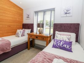 A bedroom with two single beds and a table at Angel Lodge - No 27 in Fornham St Genevieve near Bury St Edmunds