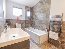 A bathroom with a bathtub and sink at Angel Lodge - No 27 in Fornham St Genevieve near Bury St Edmunds
