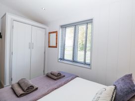 A bedroom with a bed and wardrobe at Angel Lodge - No 27, Fornham St Genevieve near Bury St Edmunds