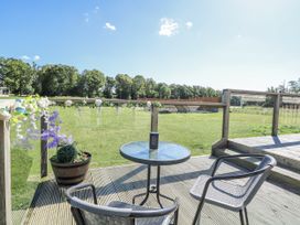 An outdoor seating area with a table and chairs at Angel Lodge - No 27 Fornham St Genevieve near Bury St Edmunds