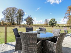 An outdoor seating area with a table and chairs at Angel Lodge - No 27 Fornham St Genevieve near Bury St Edmunds