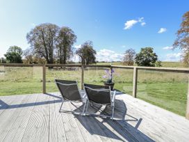 An outdoor area with chairs on a deck at Angel Lodge - No 27 in Fornham St Genevieve near Bury St Edmunds